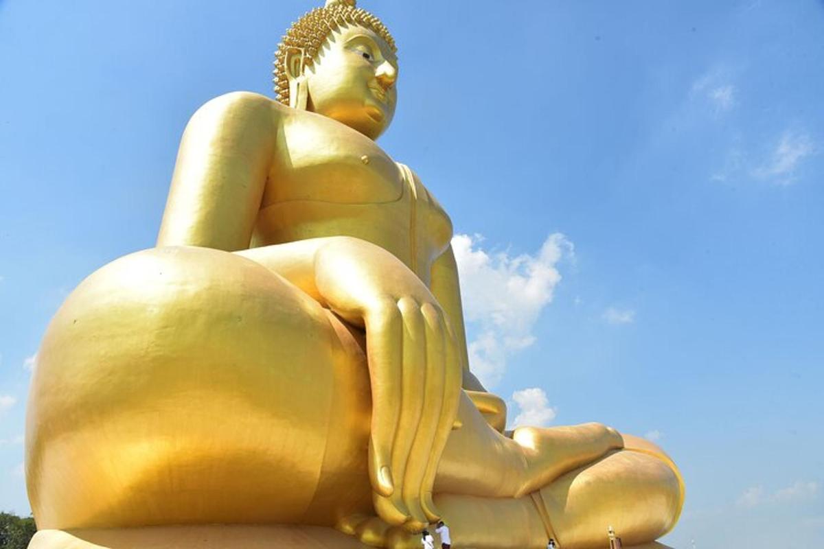 uma estátua dourada de uma mulher sentada em uma rocha