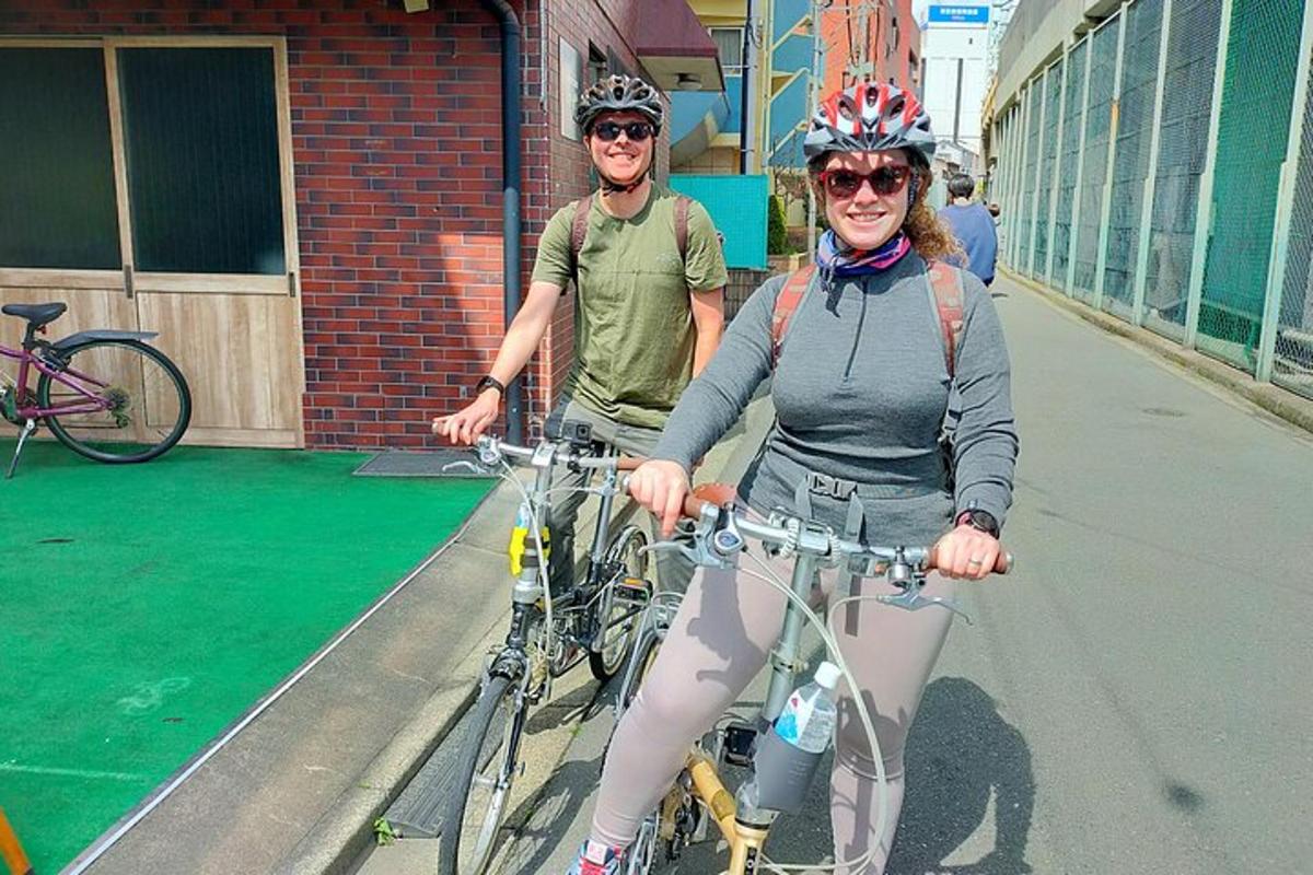 Un par de personas andando en bicicleta por una calle.