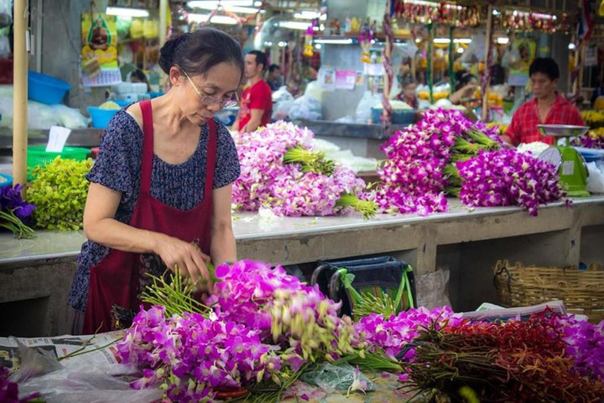 eine Frau arrangiert lila Blumen auf einem Markt