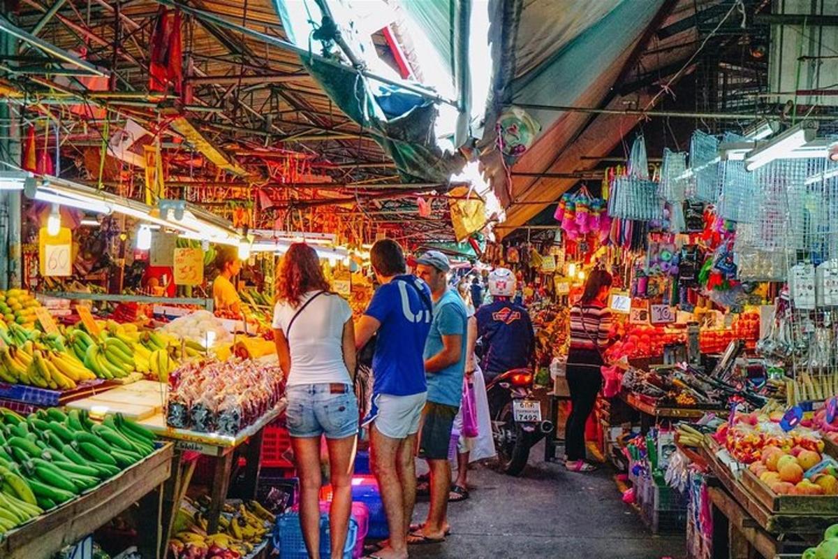 eine Gruppe von Menschen, die mit Obst und Gemüse durch einen Markt gehen