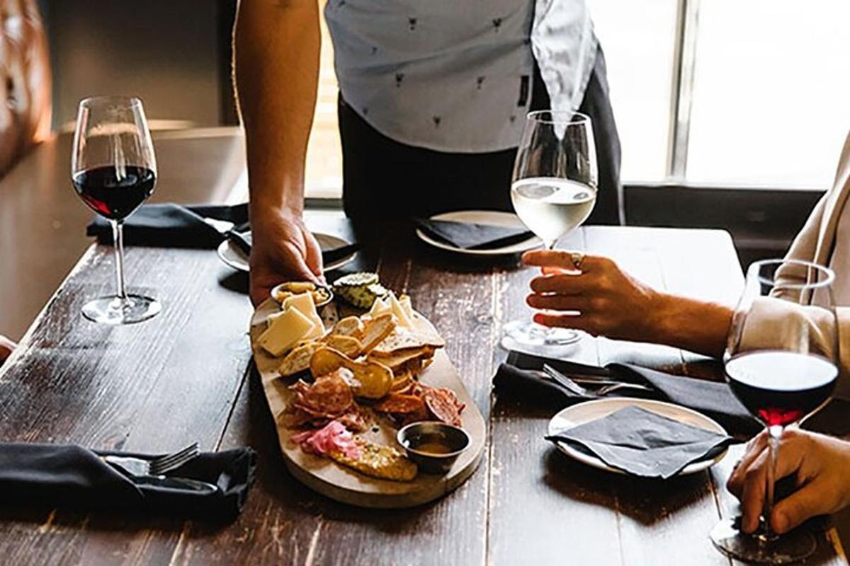 Una mesa con un plato de comida y dos copas de vino.
