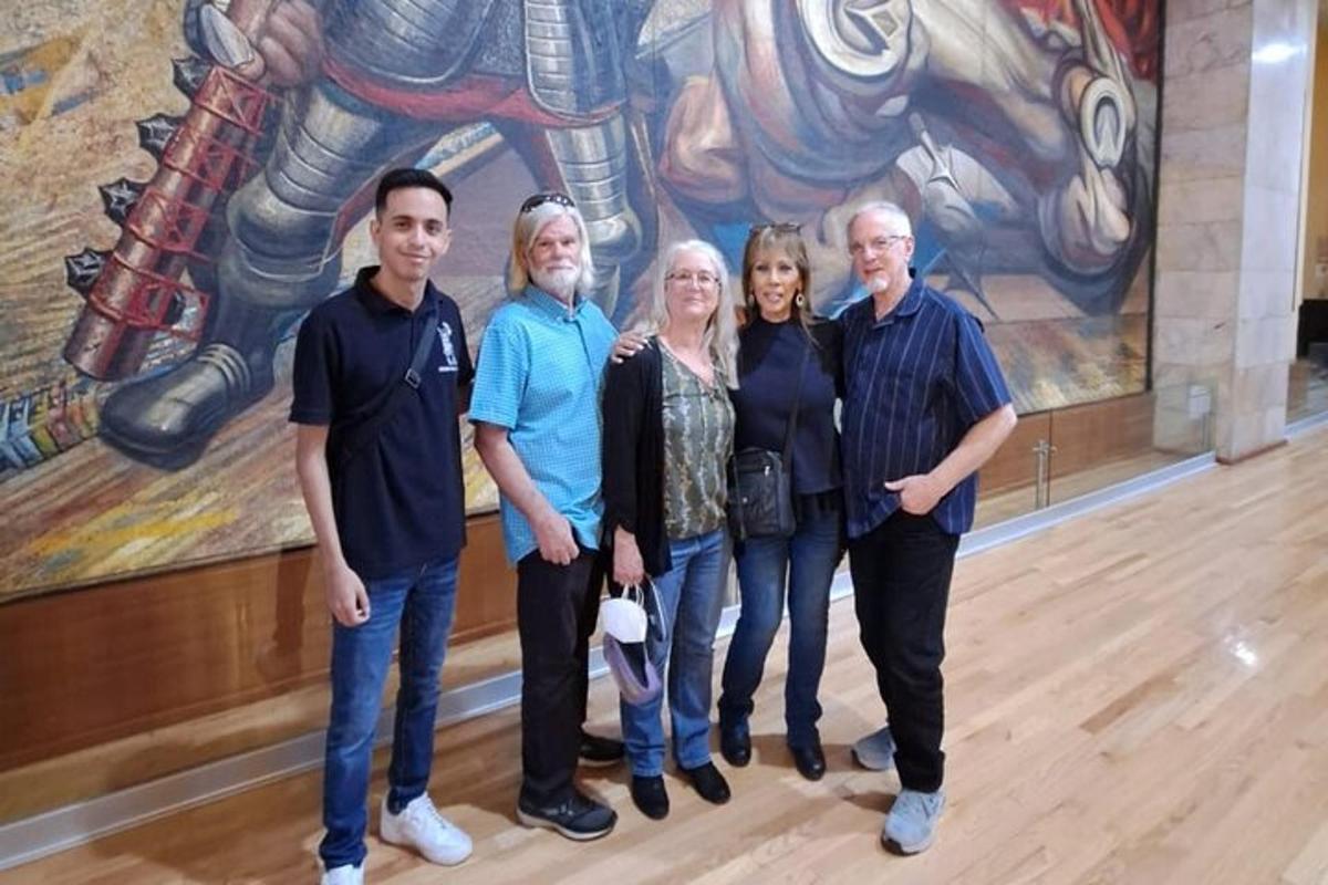 a group of people standing in front of a painting