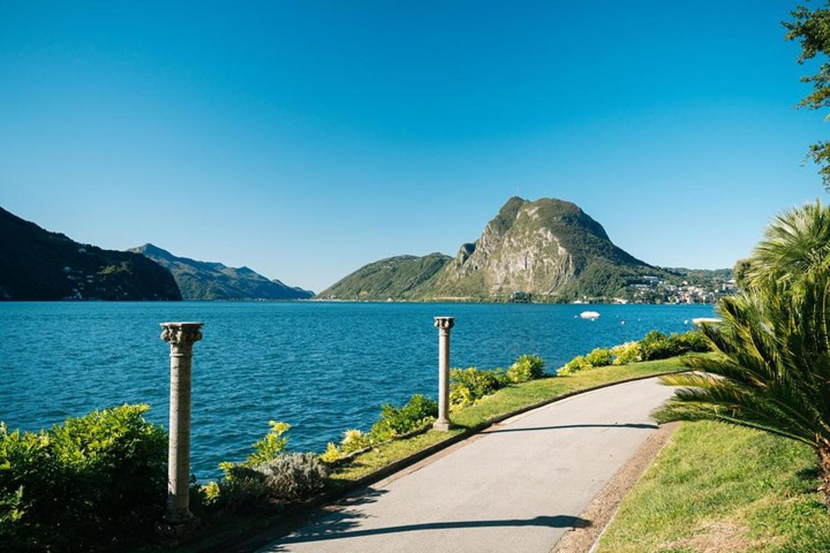 a road next to a body of water with a mountain