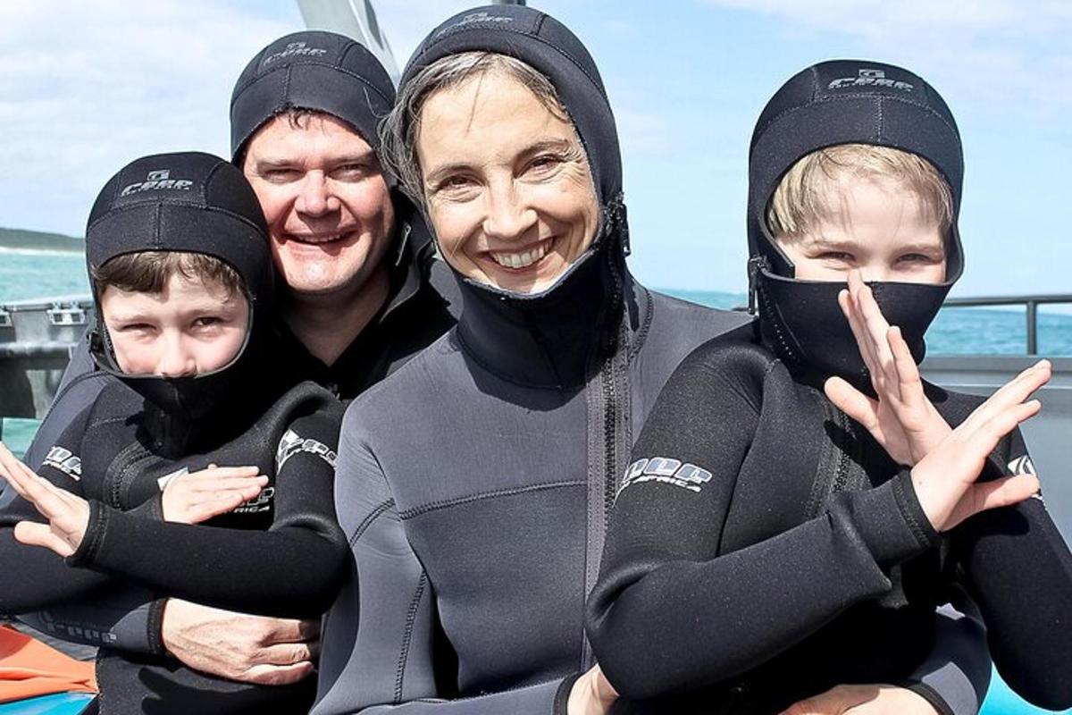 Þriggja manna hópur í blautbúningum að pósa fyrir myndatöku