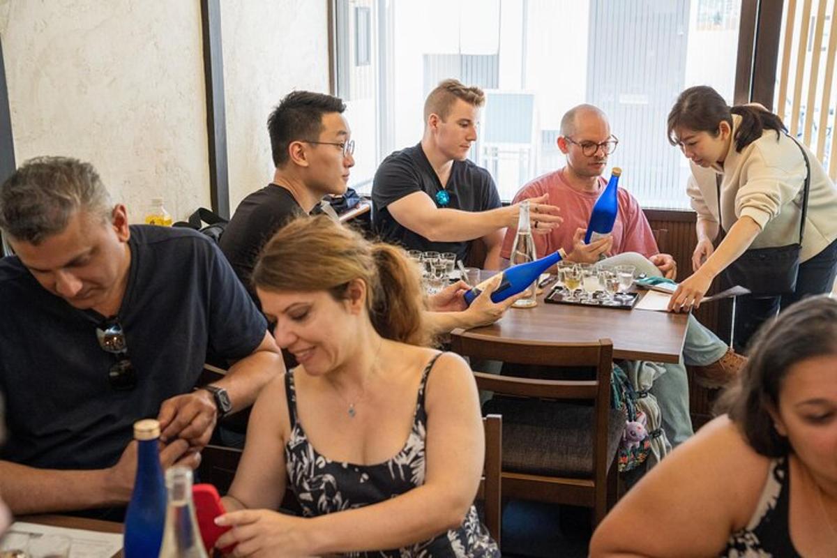 skupina lidí sedících kolem stolu s modrými vázami