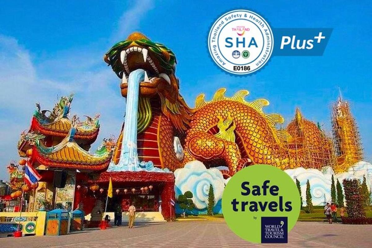 a large dragon statue in front of a ride at a carnival