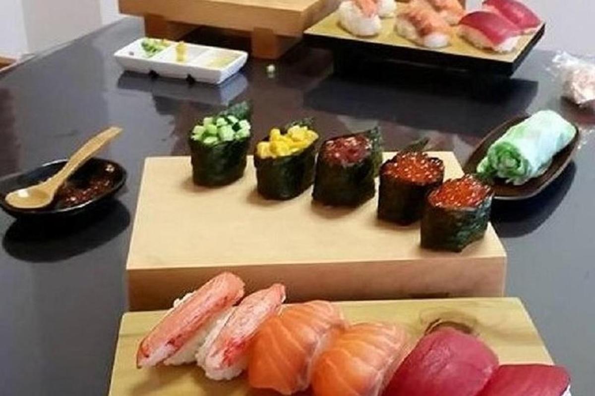 meja yang diisi dengan sushi dan makanan lainnya