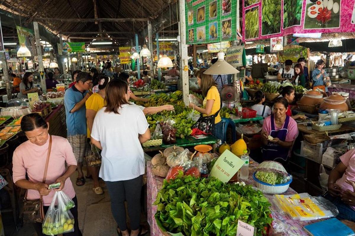 Un grupo de personas en un mercado con productos agrícolas.