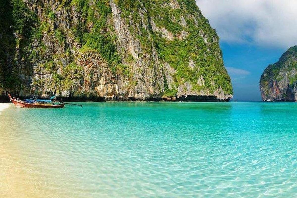 una barca ferma sulla spiaggia accanto a una montagna