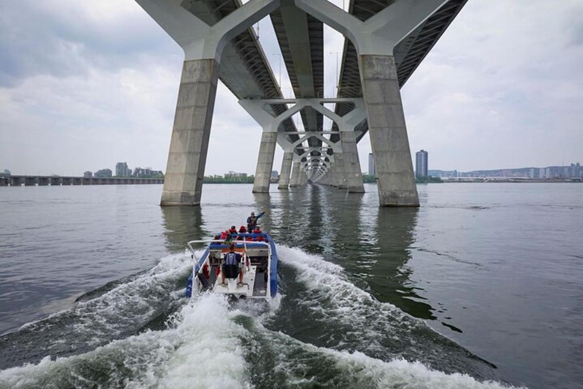um grupo de pessoas em um barco sob uma ponte