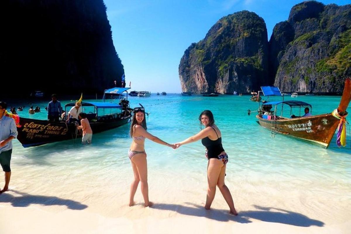 dua wanita berdiri di pantai berpegangan tangan