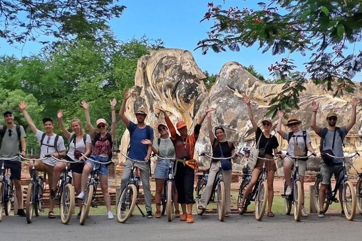 un grup de oameni pe biciclete în fața unei formațiuni stâncoase