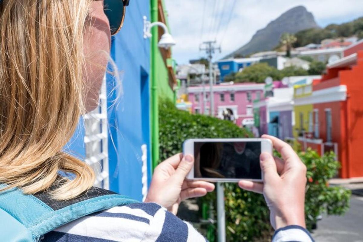 egy nő fényképez egy várost a mobiltelefonjával