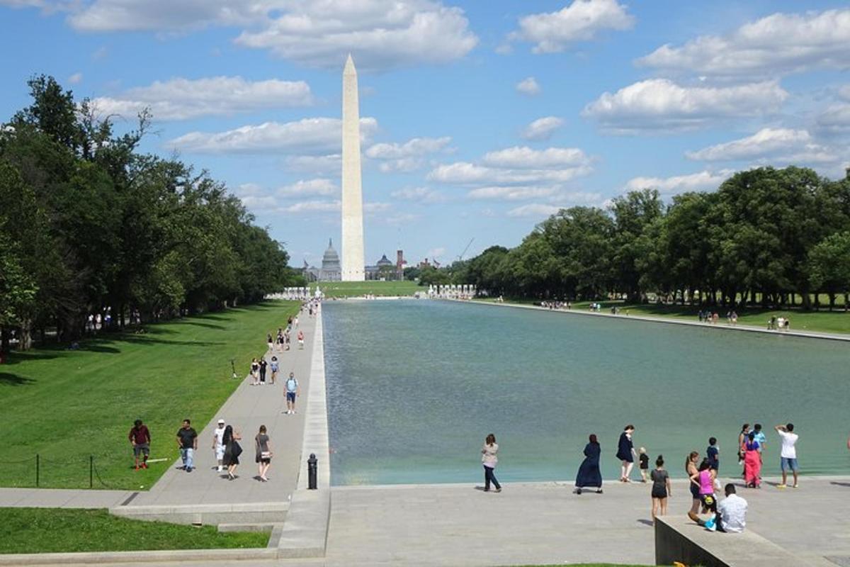 một nhóm người đang đi bộ xung quanh tượng đài washington