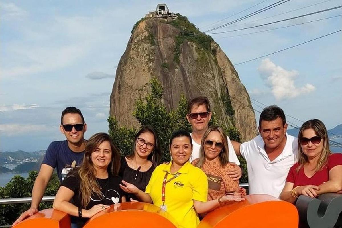 un grup de oameni care pozează pentru o fotografie în fața unei stânci