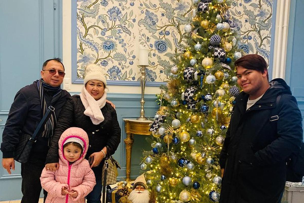 un gruppo di persone in piedi accanto a un albero di Natale