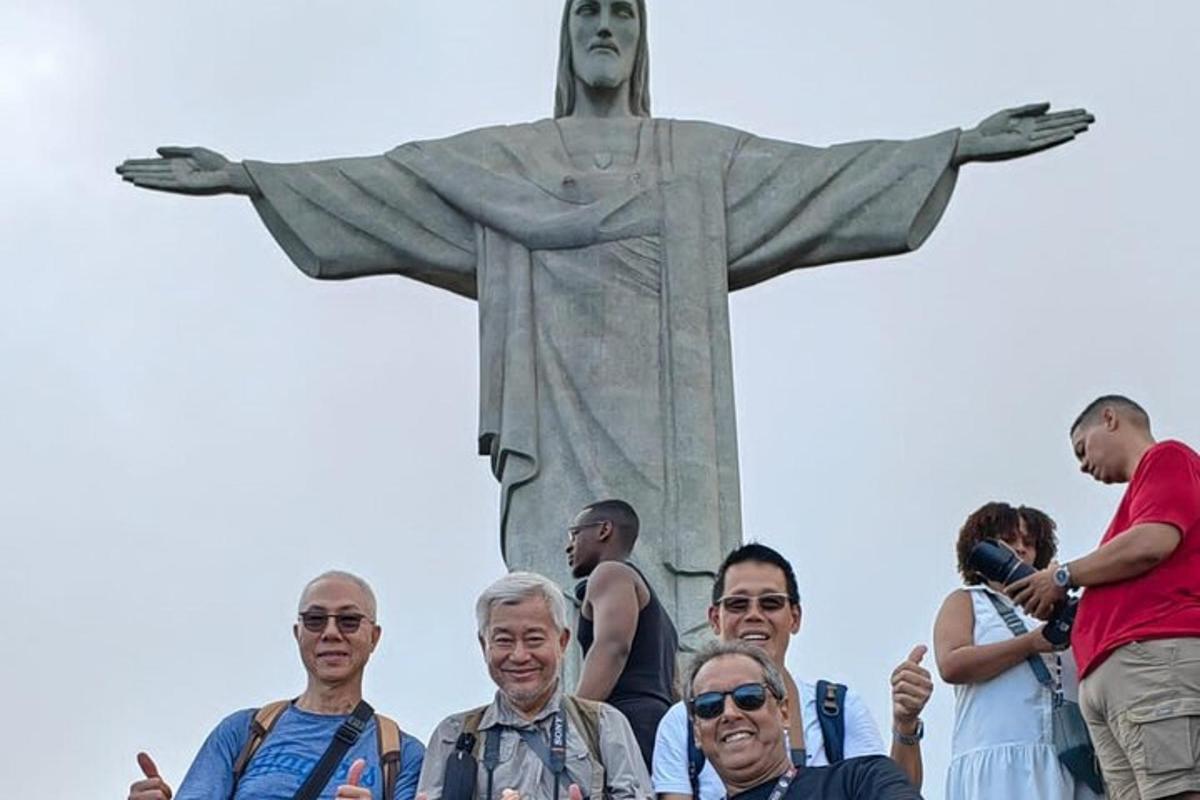 a group of people standing in front of the christ the redeemer statue