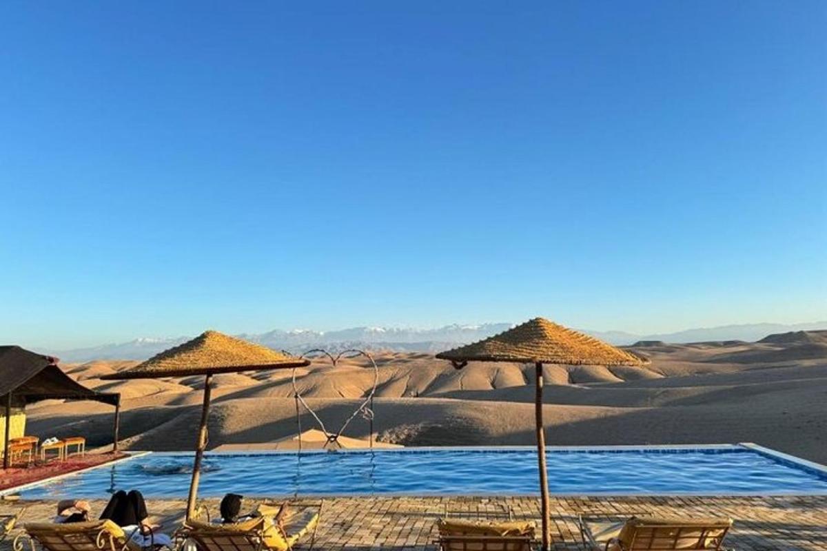 a group of people sitting in chairs and umbrellas in the desert