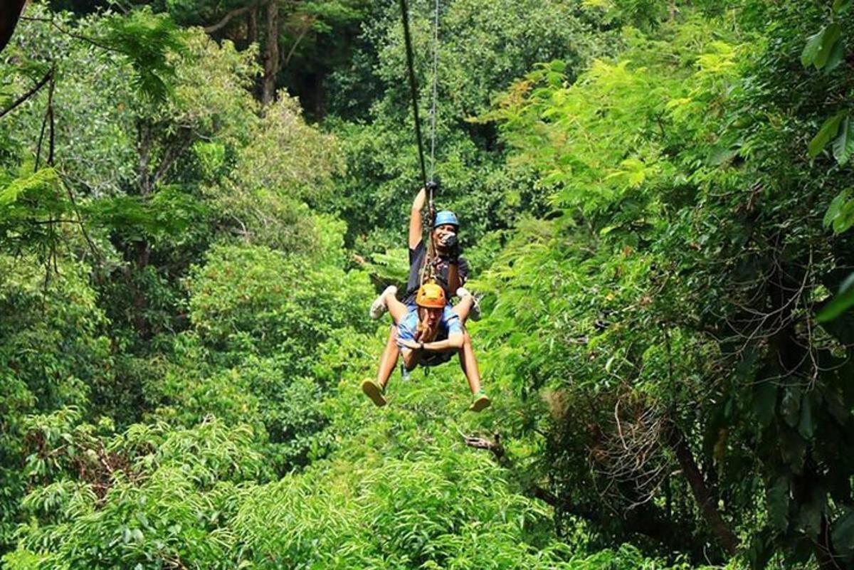 two people on a zip line in the jungle