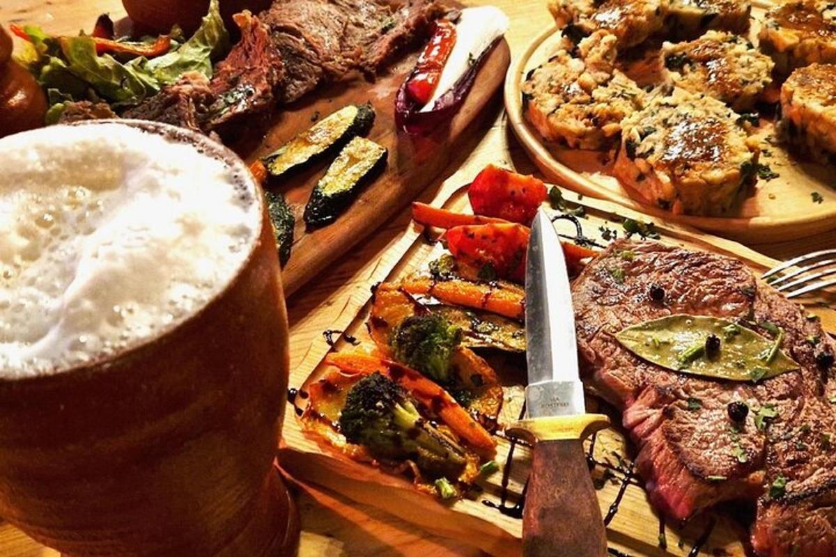 Una mesa con un plato de comida y un vaso de cerveza.