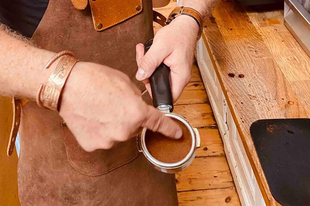egy férfi egy csésze kávét tart a kezében