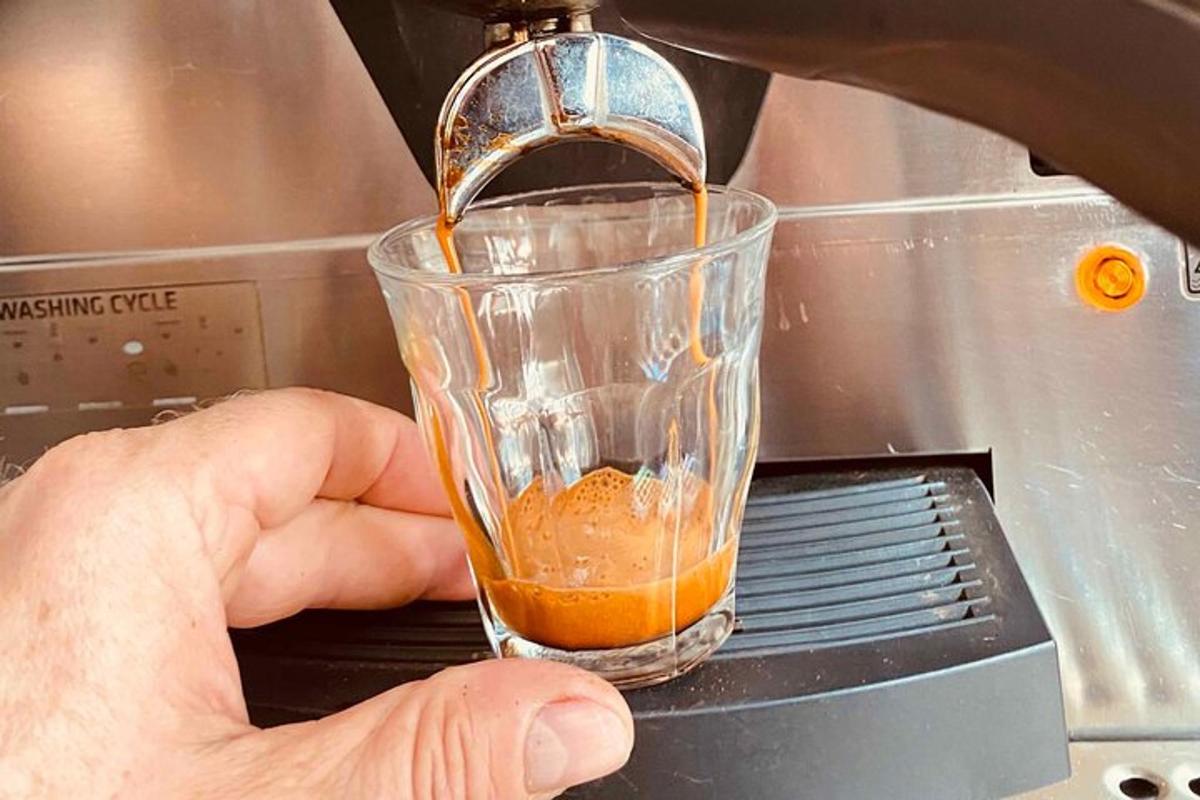egy személy egy csészét és egy keverőt tart a kezében