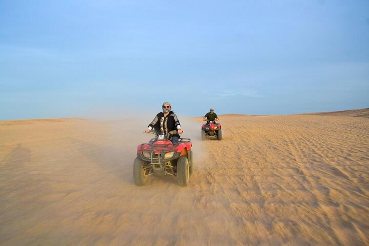 dua orang menunggang atv di padang pasir