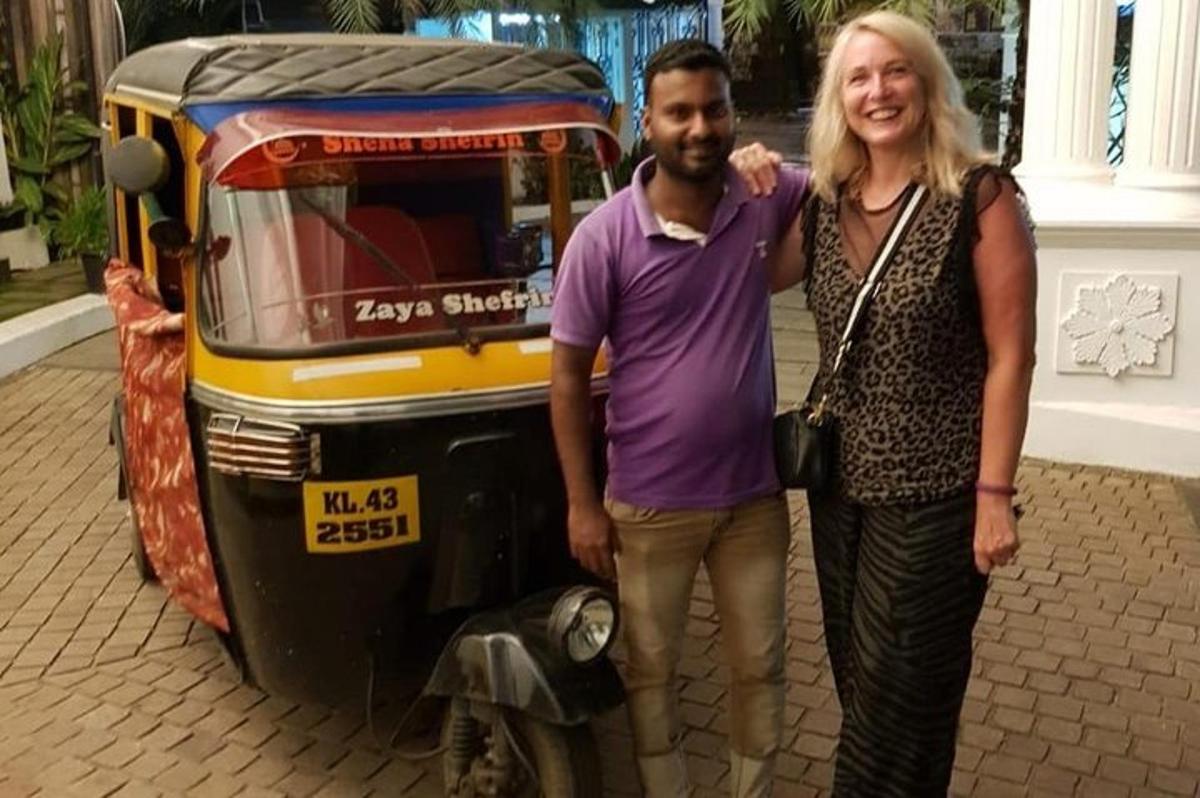 a man and a woman standing next to a motorcycle
