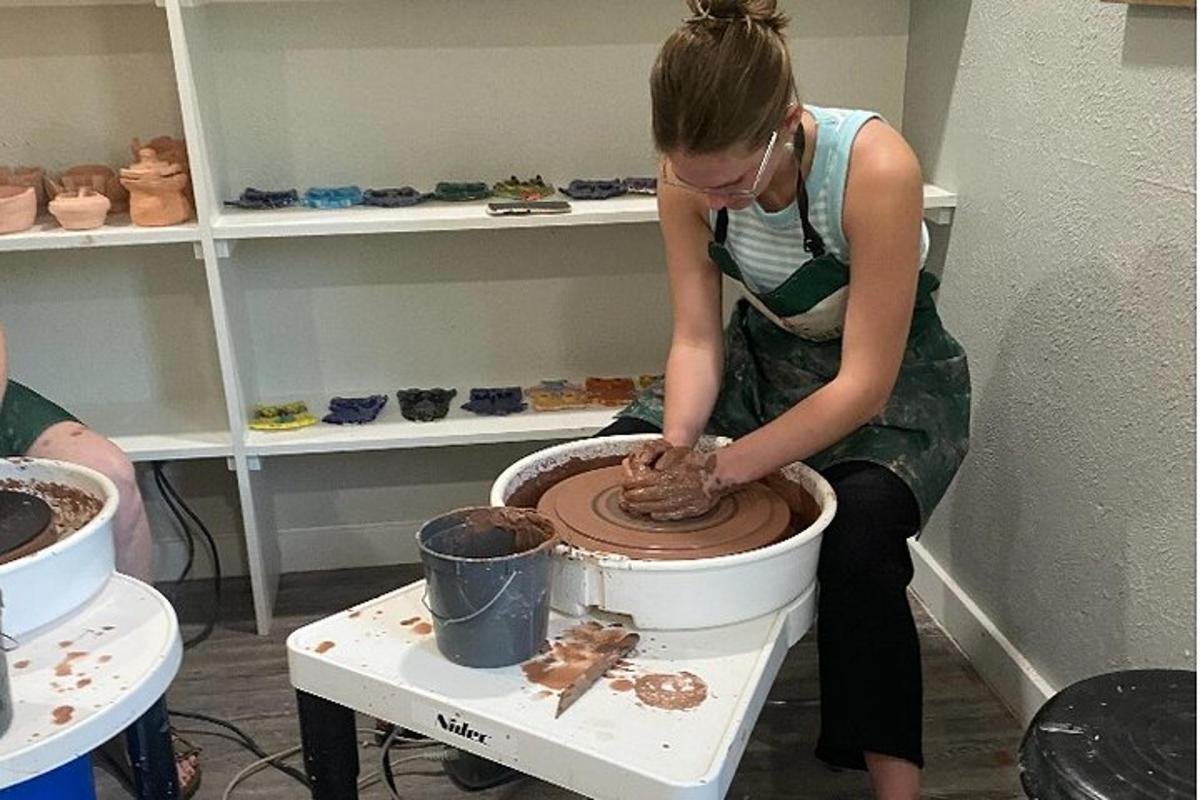 a woman is working on a pottery wheel
