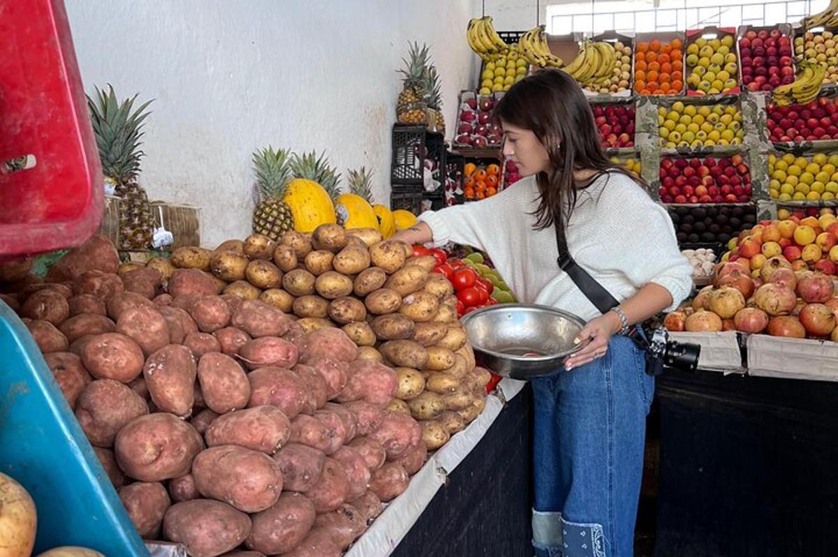 a woman standing in a market with a bunch of fruit