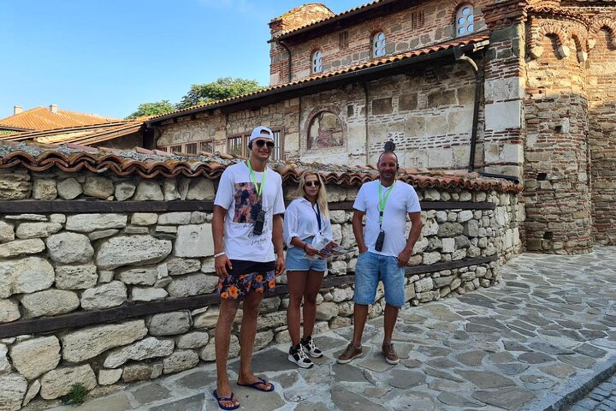 a group of people standing in front of a stone wall