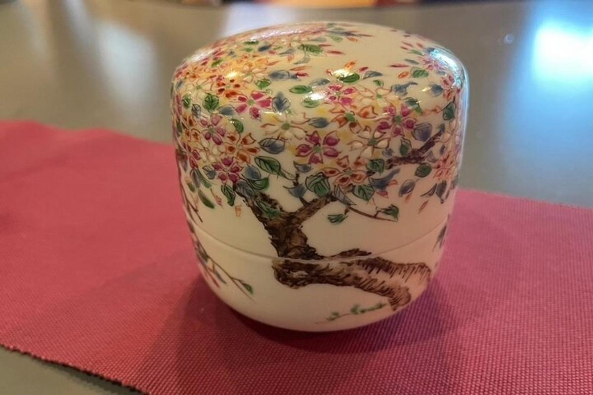 a vase with a tree painted on it on a table