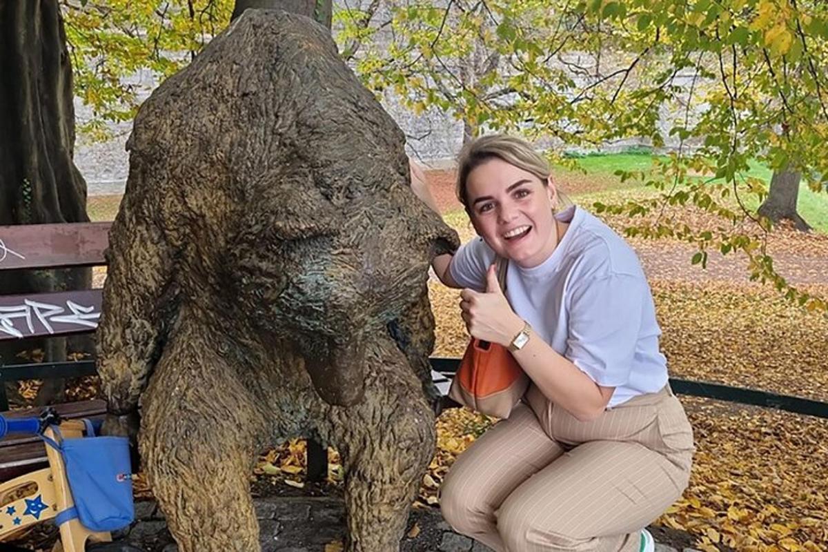 a woman kneeling next to a statue of a bear