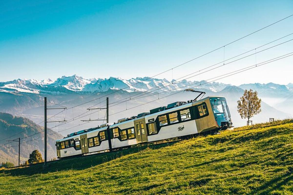 a train on a hill with mountains in the background