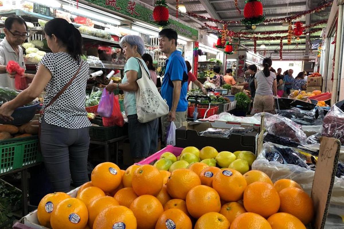isang grupo ng mga tao sa isang palengke na may dalandan at mansanas
