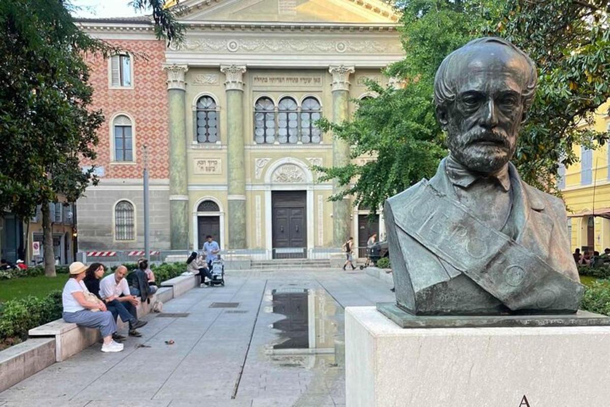 socha muže sedícího před budovou