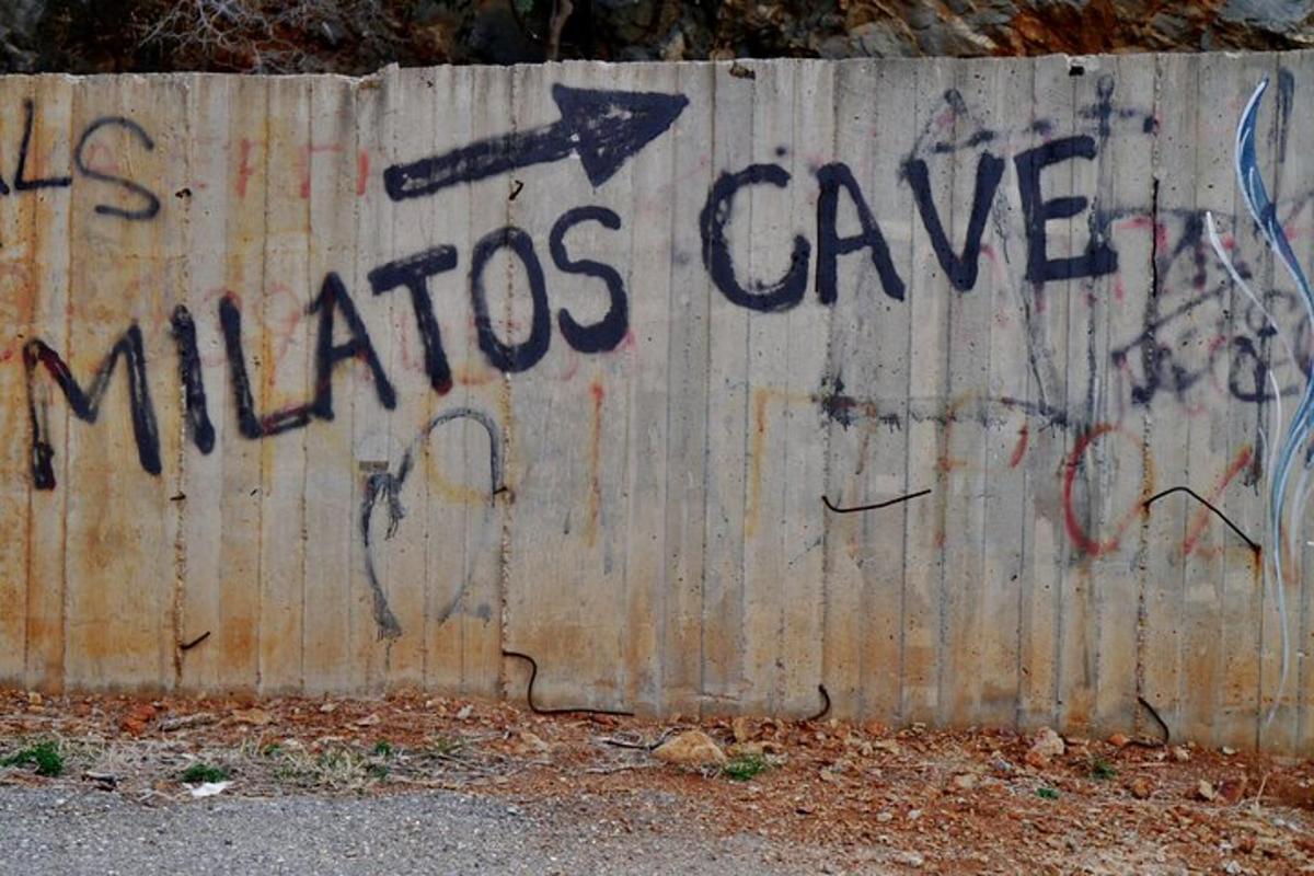 Una pared con un cartel que dice cueva de milos