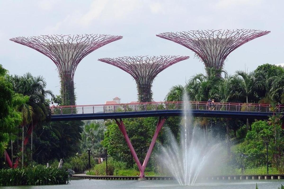 a bridge over a fountain in a park with a waterfall