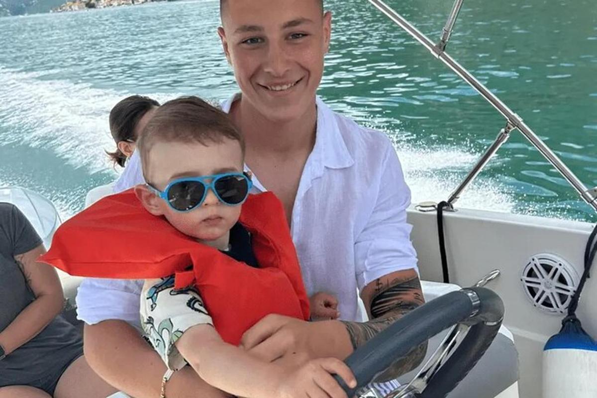 a man holding a young boy on a boat