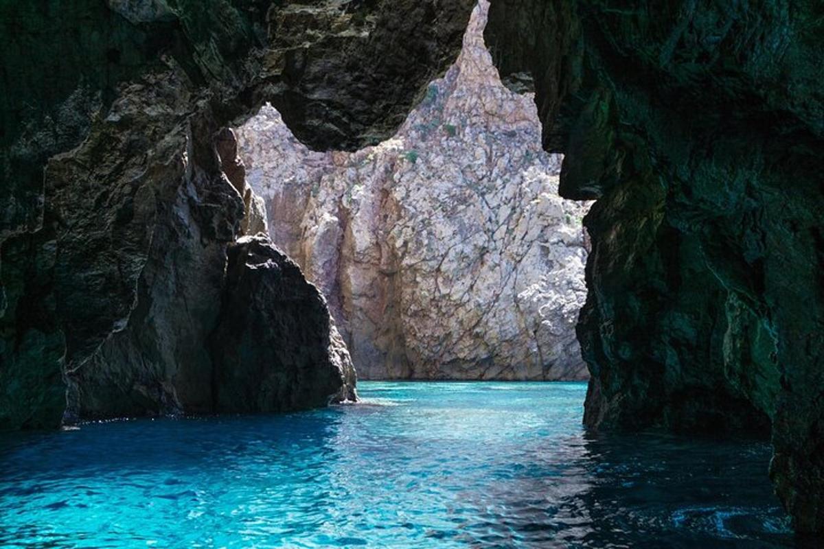 een grot met blauw water en rotsen erin