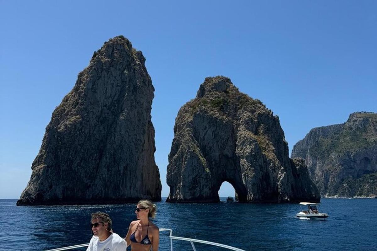 dues persones en un vaixell a l'aigua amb una formació rocosa
