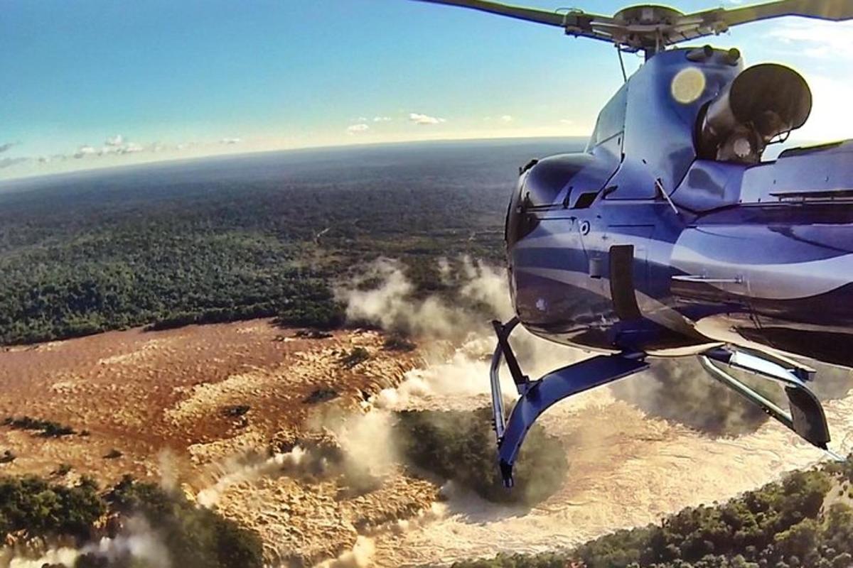 a blue helicopter is flying over a field