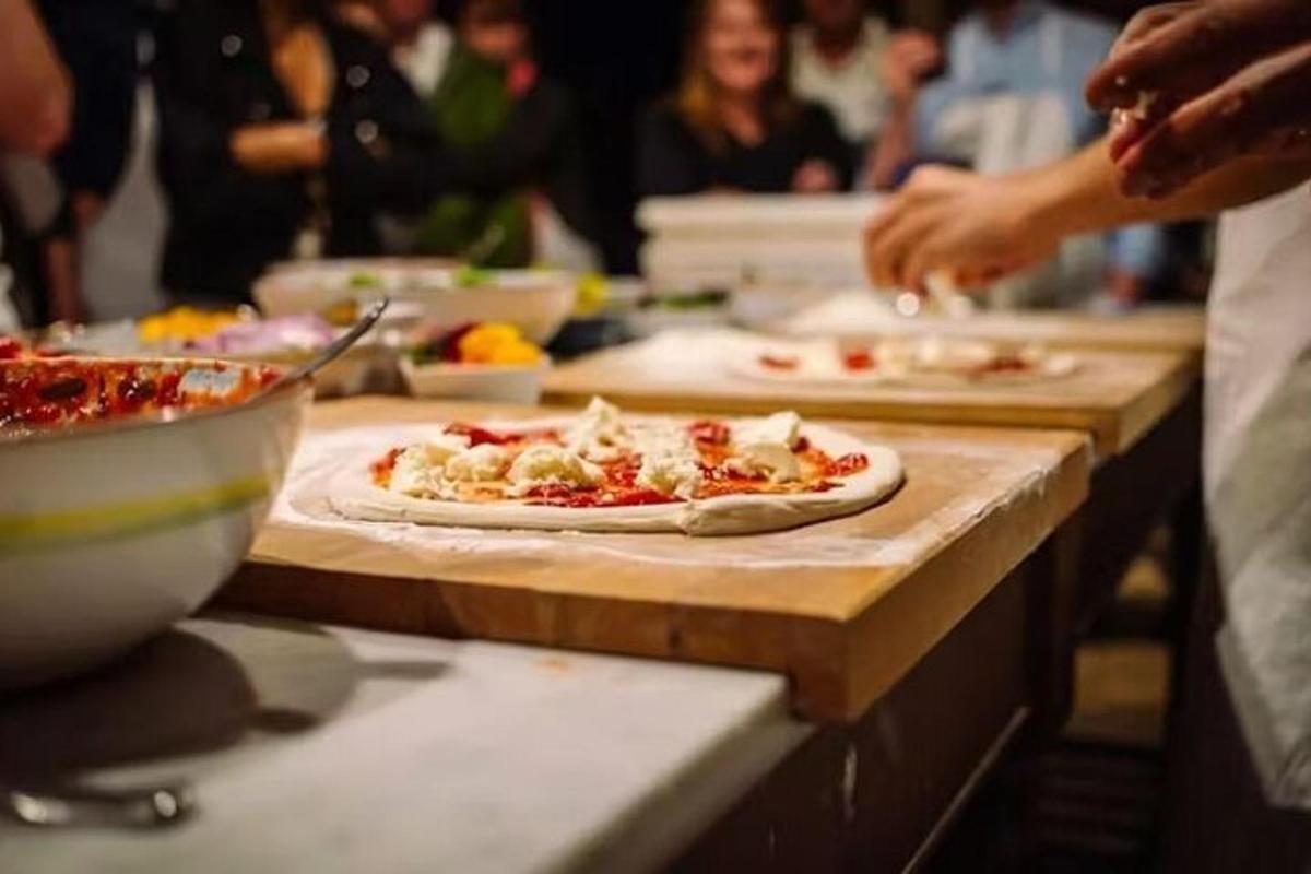 một nhóm người đang làm pizza trên bàn
