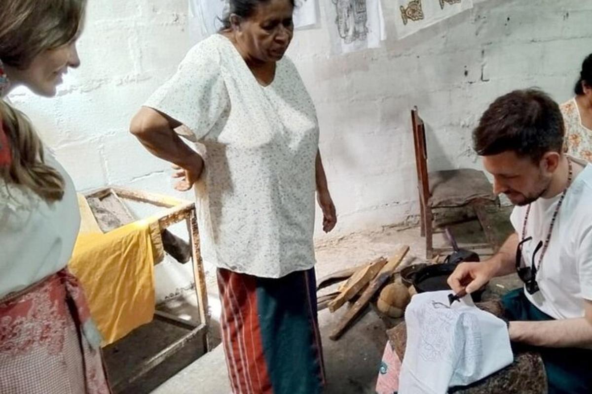 a woman standing next to a man cutting a piece of paper