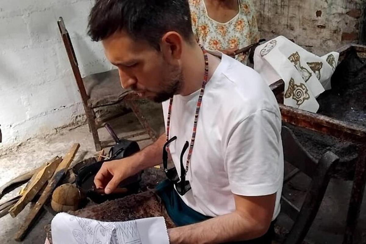 a man with a camera around his neck working on something