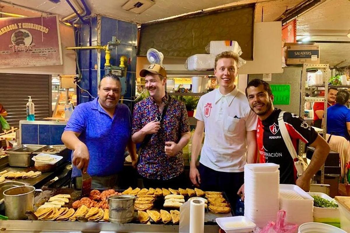 um grupo de homens em pé em uma cozinha com comida