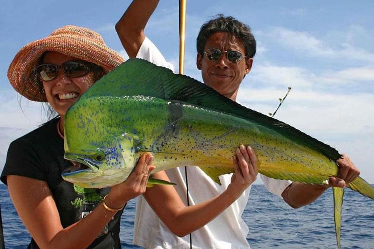 un uomo e una donna che tengono in mano un grosso pesce