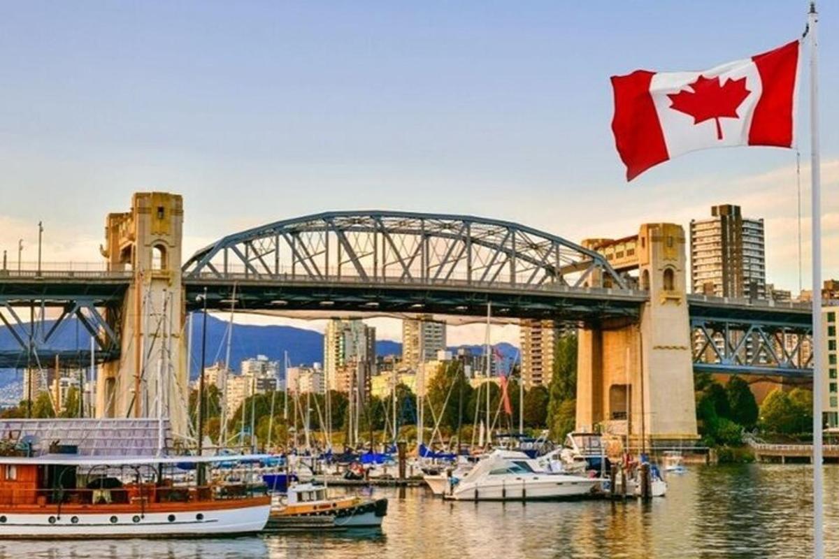 un steag canadian fluturând în fața unui pod