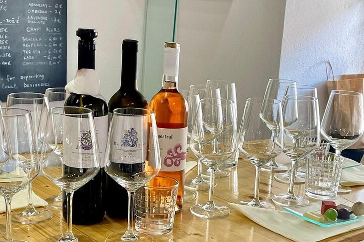 o grămadă de sticle și pahare de vin pe o masă