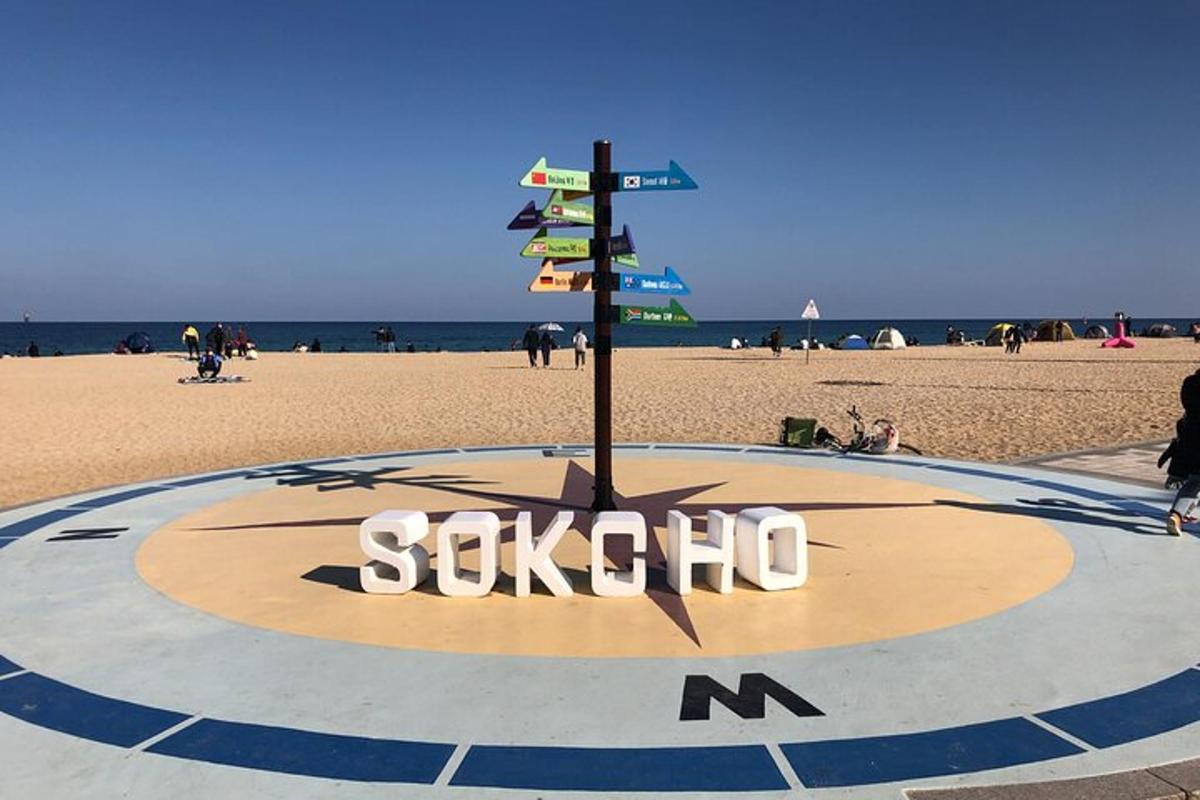 et skilt på en strand med folk på stranden